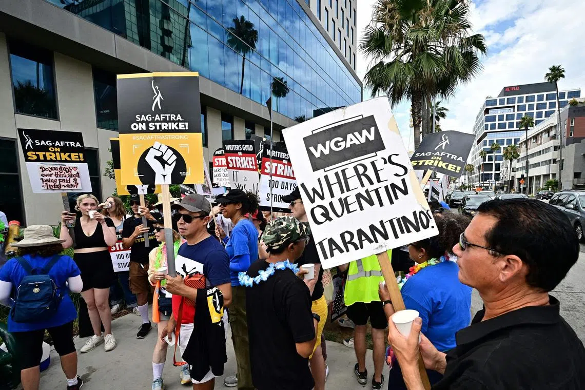 Members of the Writers Guild of America (WGA) and the Screen Actors Guild walk the picket line outside of Netflix in Hollywood, California, on August 9, 2023. Film and TV production ground to a halt 100 days ago when writers downed their pens, only to be joined on the picket lines in mid-July by actors. (Photo by Frederic J. BROWN / AFP)