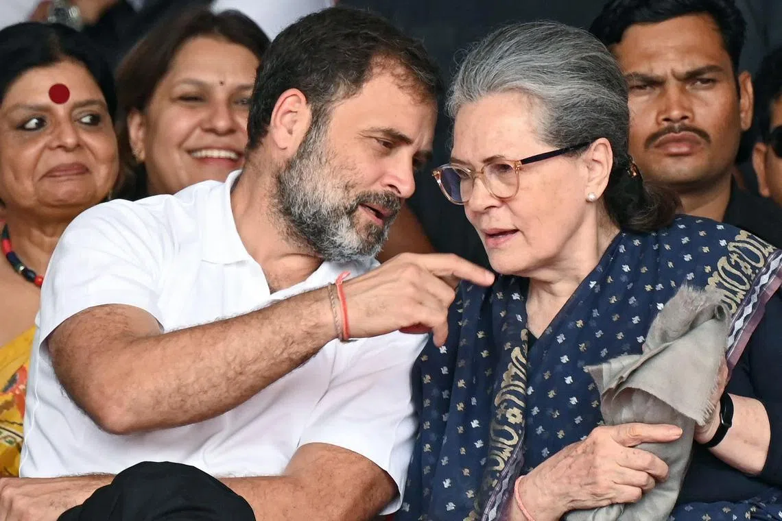 Congress party leaders Rahul Gandhi and Sonia Gandhi (R) talk during swearing in ceremony of Chief Minister of Telangana state, in Hyderabad on December 7, 2023. (Photo by NOAH SEELAM / AFP)