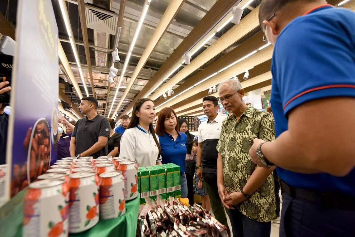 Minister for Social and Family Development Masagos Zulkifli viewing the Iftar Bites station where Muslims can help themselves to the free drinks and snacks or dates at 60 FairPrice outlets during Ramadan.