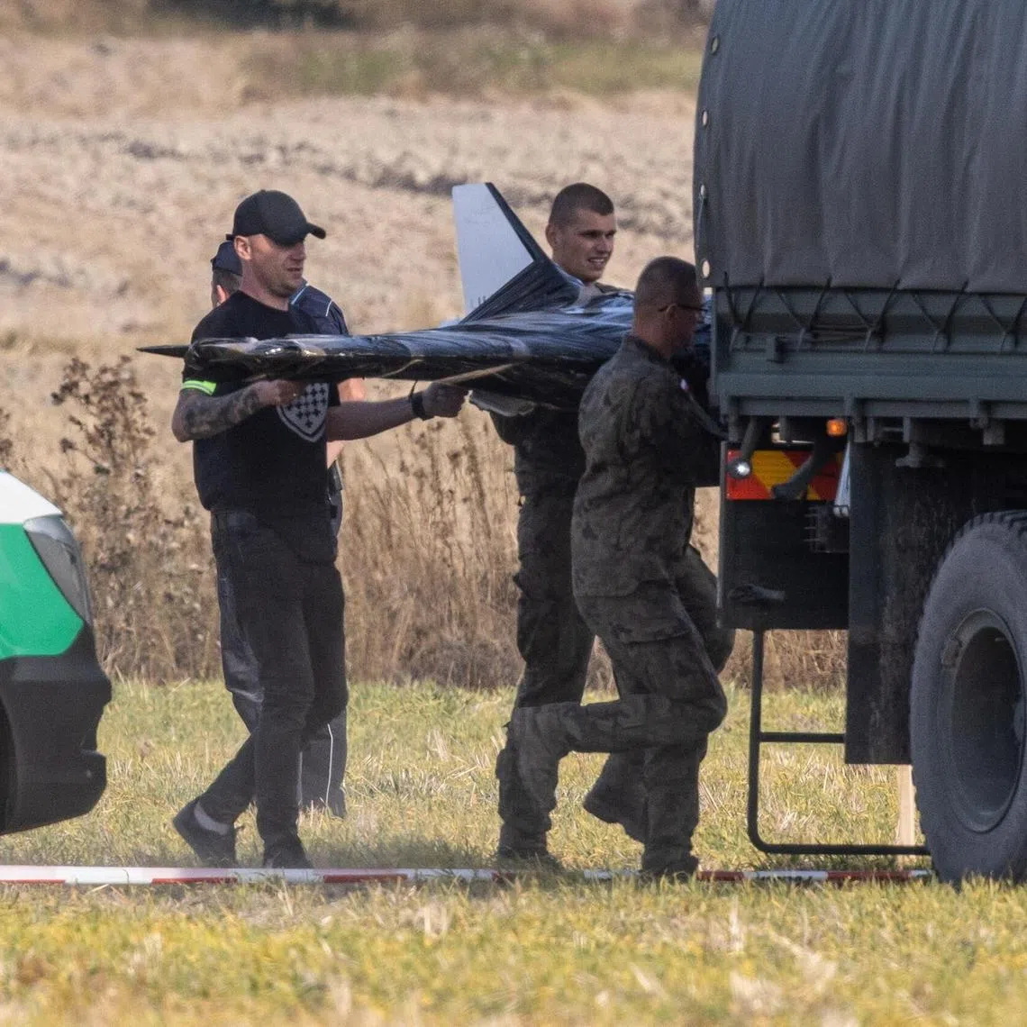 Polish territorial defence officials at the crash site of a Russian drone in the village of Wohyn, eastern Poland, on Sept 10.
