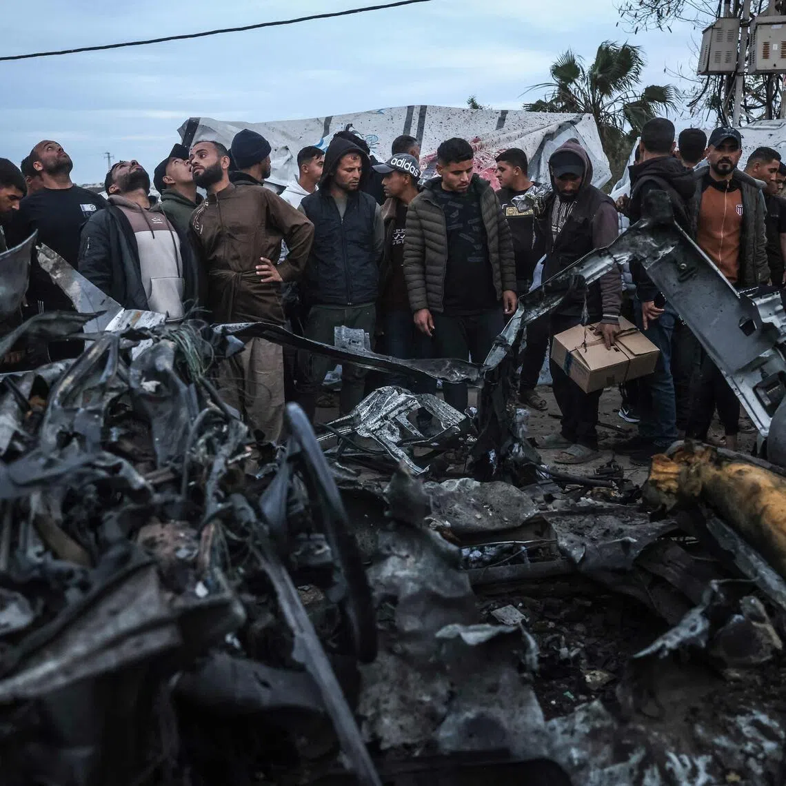 People gather at the site of an Israeli strike on a police vehicle in Khan Yunis, in the southern Gaza Strip on April 24, 2026. 