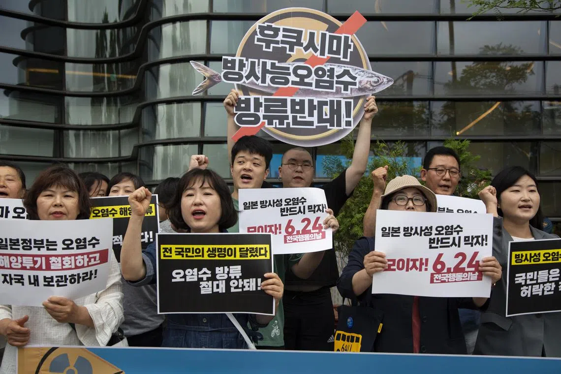 embers of environmental groups shout slogans and hold banners reading 'No, Fukushima radioactive water' during a rally against Japan's disposal of radioactive water, outside the Japanese Embassy in Seoul.
