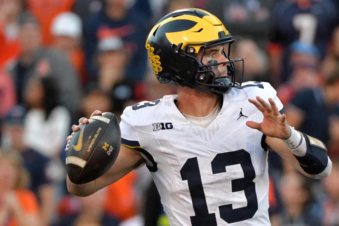 FILE PHOTO: Oct 19, 2024; Champaign, Illinois, USA;  Michigan Wolverines quarterback Jack Tuttle (13) throws against the Illinois Fighting Illini during the second half at Memorial Stadium. Mandatory Credit: Ron Johnson-Imagn Images/File Photo