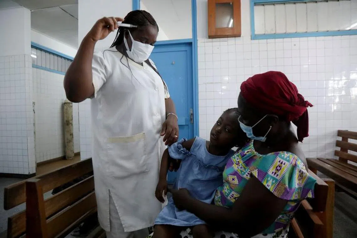 A nurse prepares to take the temperature of a child with malaria at Marcory General Hospital in Abidjan, Ivory Coast October 7, 2021. REUTERS/Luc Gnago/ File photo