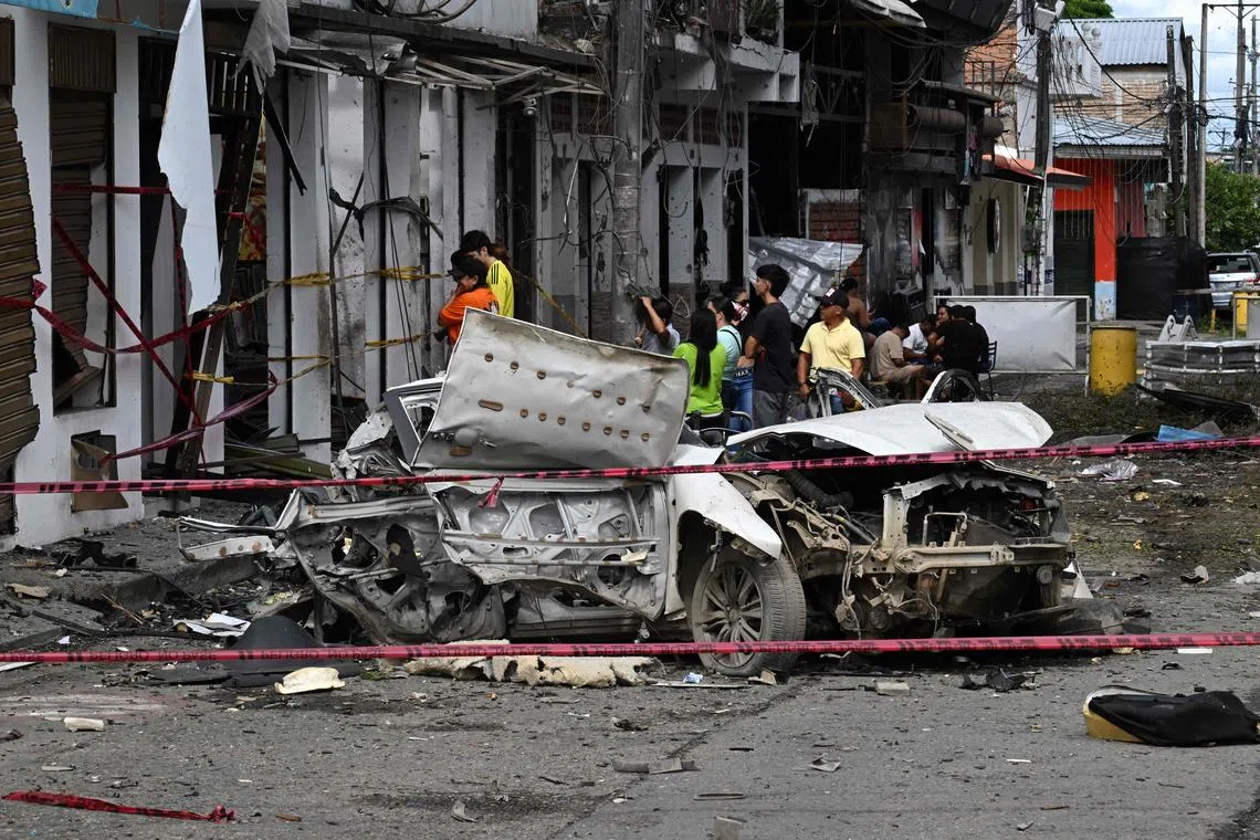 Bystanders looking at destroyed buildings after a car exploded in front of the City Hall in Corinto, Colombia, on June 10.