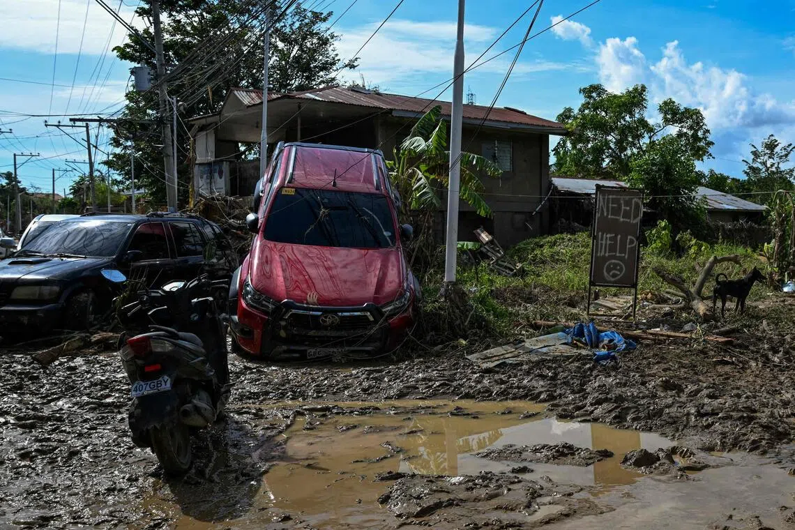 Cars piled atop each other by floodwaters and roofs torn off buildings as residents attempted to dig out of the mud at Liloan, a town near Cebu city.