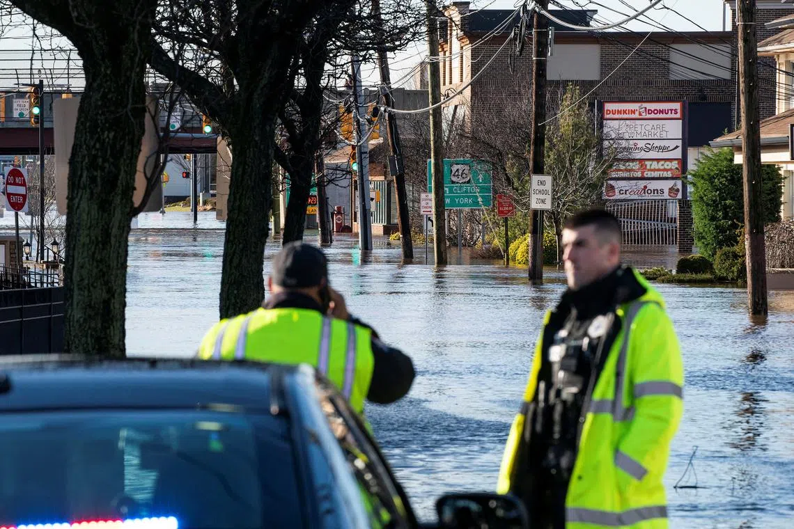 New Jersey Police Officers block the access to a local street flooded during the pass of a winter storm in Lodi, New Jersey, on Jan 10, 2024.