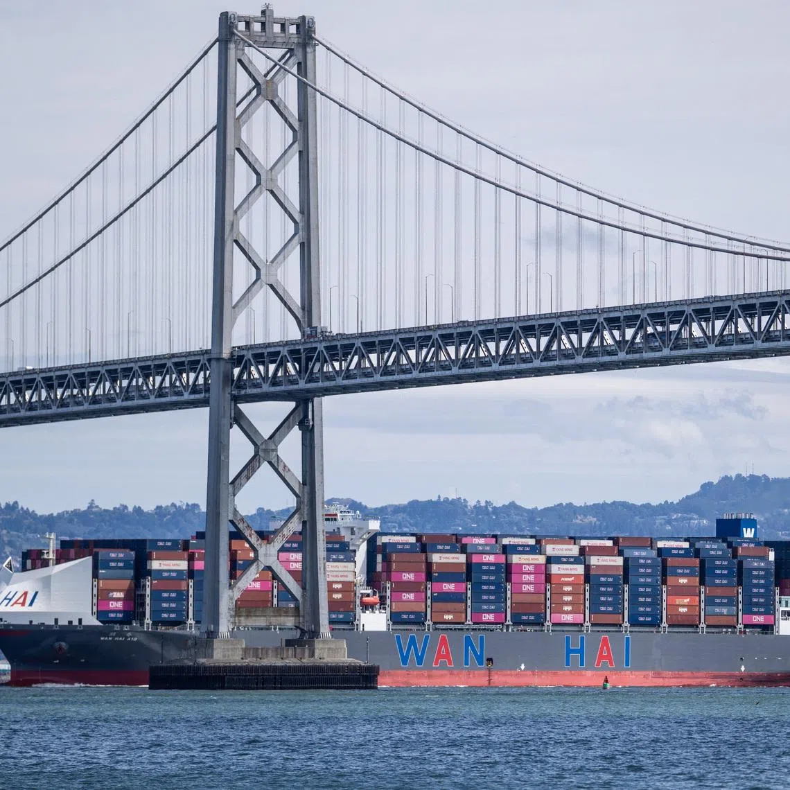 FILE PHOTO: A container ship passes under the San Francisco-Oakland Bay Bridge, in San Francisco, California, U.S., April 9, 2026. REUTERS/Carlos Barria/ File Photo