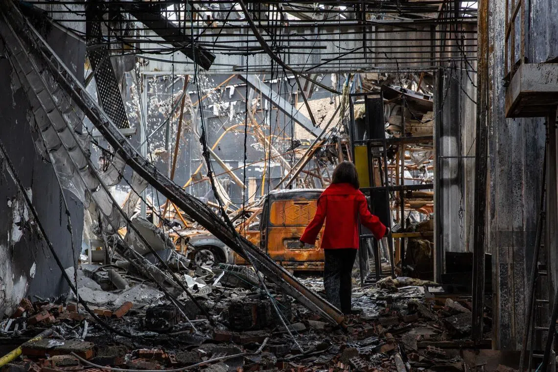 A girl steps through the ruins of an auto service center that was targeted by US-Israeli airstrikes in Tehran, Iran.