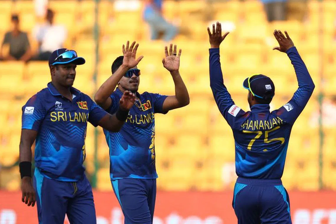 Cricket - ICC Cricket World Cup 2023 - England v Sri Lanka - M. Chinnaswamy Stadium, Bengaluru, India - October 26, 2023 Sri Lanka's Dhananjaya de Silva, Maheesh Theekshana and Angelo Mathews celebrate in a break in the innings REUTERS/Andrew Boyers