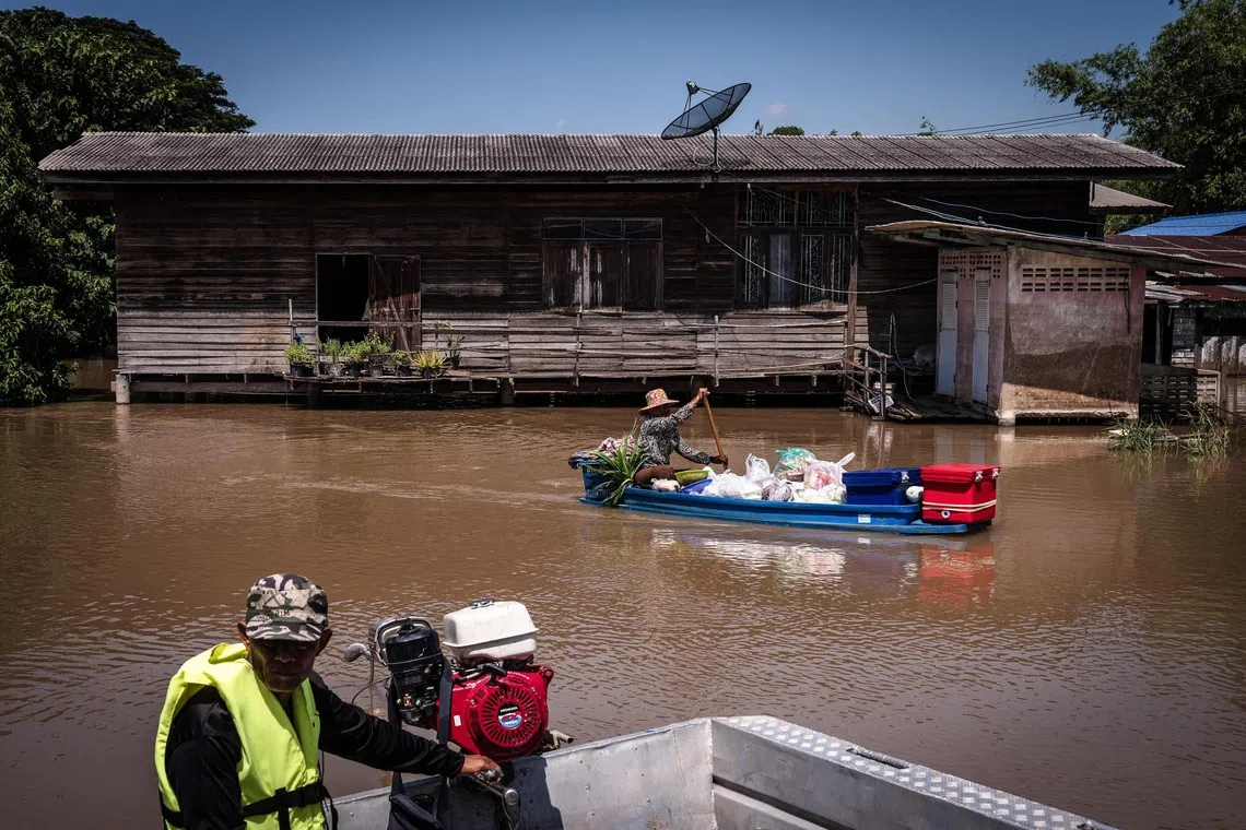 A food vendor paddling past a flooded neighbourhood in Sena district in the central Thai province of Ayutthaya.