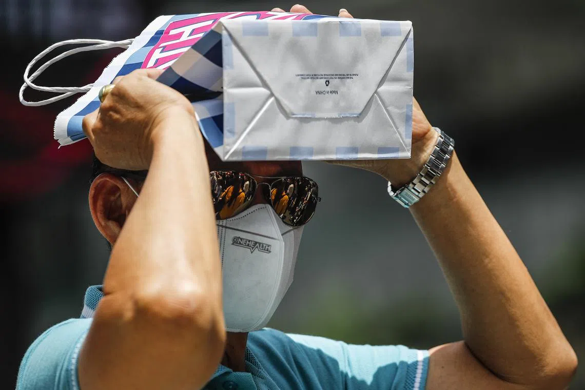 A man covers his head with a paper bag during a hot day in Kuala Lumpur, Malaysia, April 27, 2023. Malaysia is expected to experience prolonged hot weather until August, following the monsoon transition season.