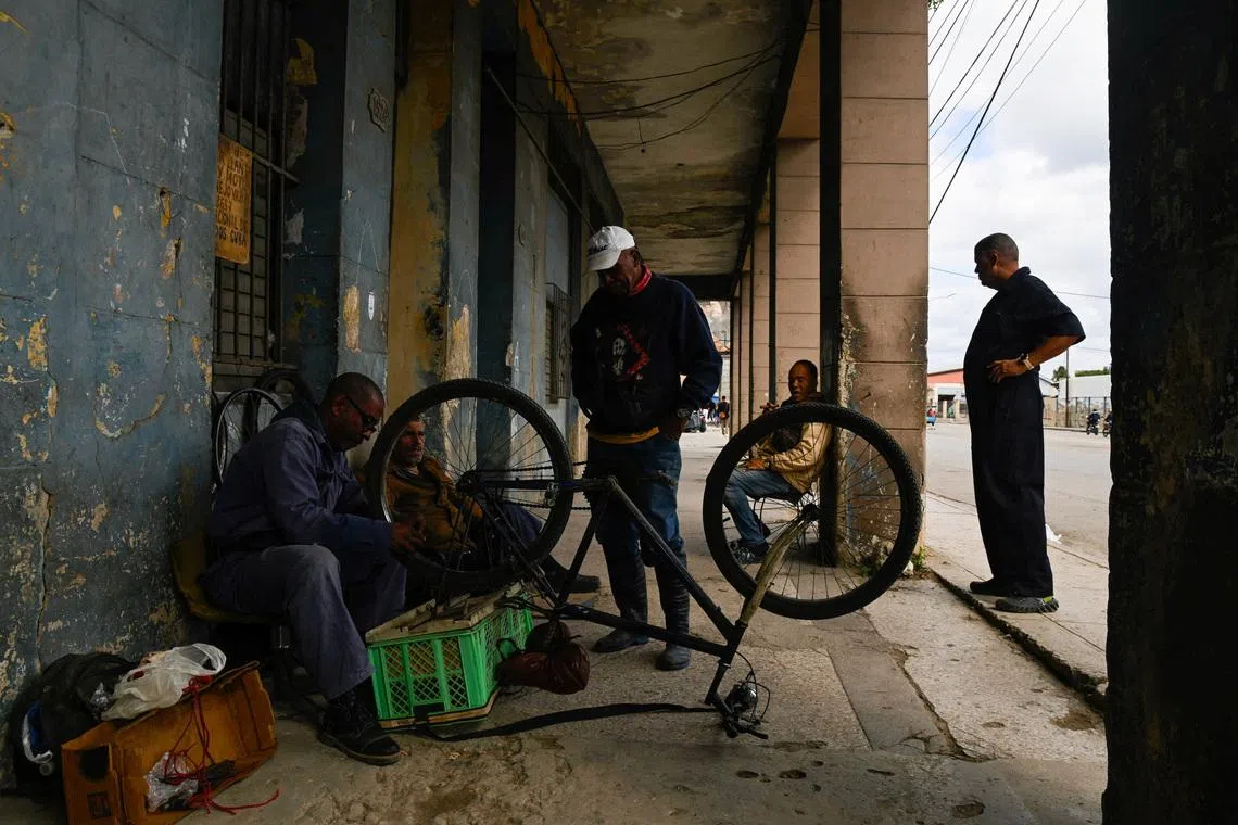 A man fixes a bicycle as Cubans brace for fuel scarcity measures after U.S. tightens oil supply blockade, in Havana, Cuba, February 6, 2026. REUTERS/Norlys Perez