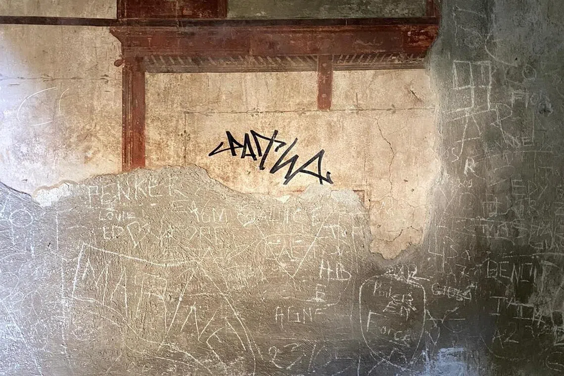A sign made with a black marker by a tourist is pictured on the wall of a domus of the Herculaneum Archaeological Park, in Ercolano, Naples, Italy, in this handout picture obtained on June 3, 2024. Carabinieri/Handout via REUTERS