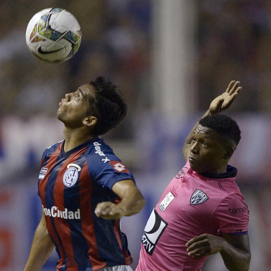 Midfielder Jonathan Gonzalez of Ecuador's Independiente del Valle, vies for the ball with defender Emmanuel Mas of Argentina's San Lorenzo during their Libertadores Cup Group 2 football match at Pedro Bidegain stadium in Buenos Aires.
