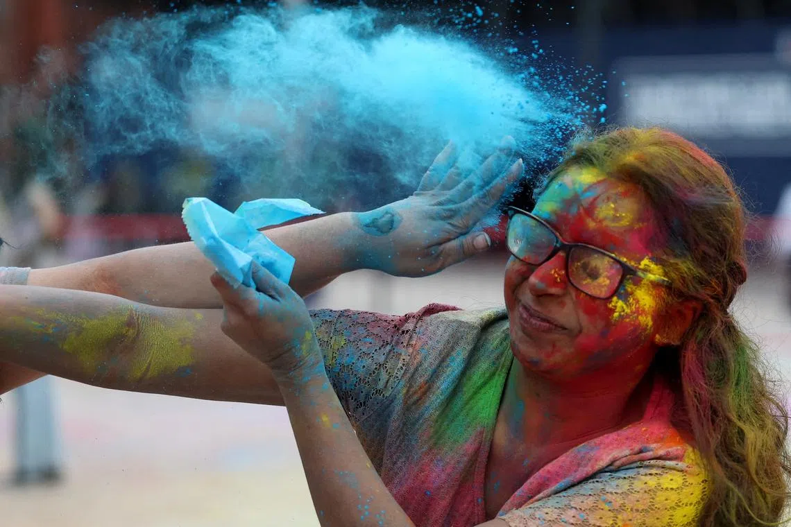 A student is covered in coloured powder during Holi festivities at Liverpool University in Liverpool, Britain, on Mar 16, 2025. 