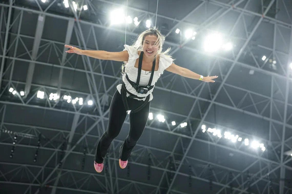 ST journalist Gabrielle Chan attempting the aerial experience during the NDP aerial performance media feature at the National Stadium on July 6.
