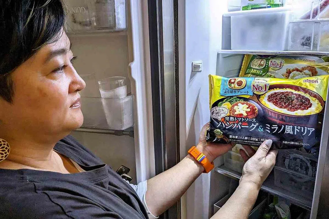 Ms Yuka Sakai takes out a split-tray meal from her freezer in Fujisawa, Kanagawa Prefecture.