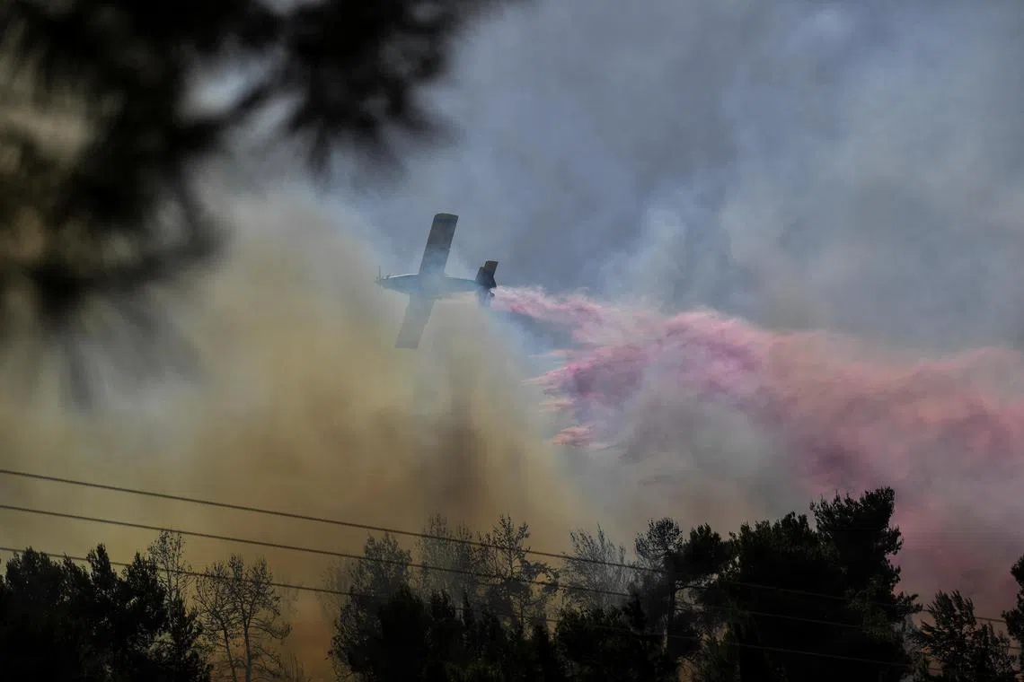 A firefighting plane disperses fire retardant on June 13, as it assists in extinguishing fires from rockets launched into Israel from Lebanon. The attacks come amid ongoing cross-border hostilities between Hezbollah and Israeli forces, in northern Israel. REUTERS