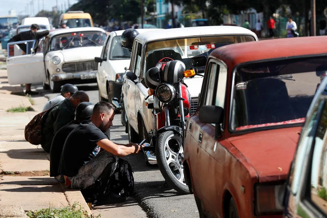 FILE PHOTO: People stand in line with their cars to fill up on fuel after Cuba's government put off a five-fold increase in gasoline prices planned for February 1 due to a cyberattack, according to Economy Vice Minister Mildrey Granadillo, in Havana, Cuba January 31, 2024. REUTERS/Yander Zamora/File Photo