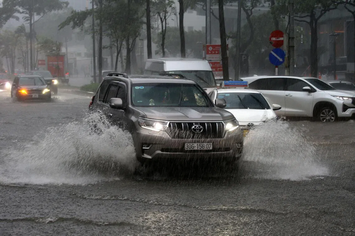 Heavy downpours flooded major roads, leaving motorbikes and cars stranded and forcing residents to wade through calf-deep water. 