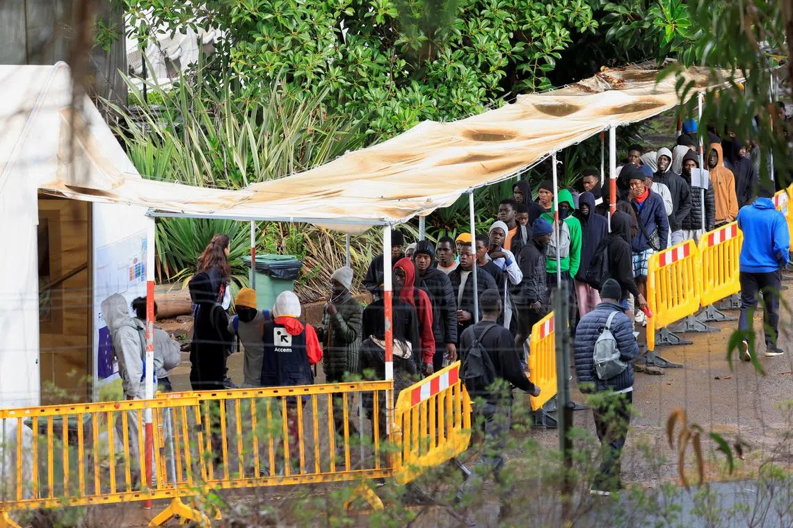FILE PHOTO: Migrants line up to eat at the Las Raices migrant camp in La Laguna, on the island of Tenerife, Spain, October 27, 2024. REUTERS/Borja Suarez/File Photo