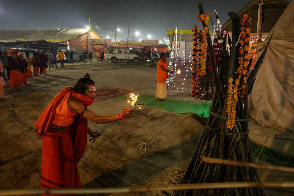 Hindu men, or Sadhus, perform evening prayers during the Maha Kumbh Mela festival in Prayagraj on Jan 17. 