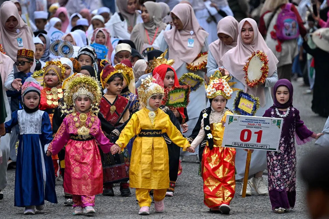 Pupils dressed in traditional Indonesian attire take part in a parade marking the Islamic new year in Banda Aceh on July 21, 2024. (Photo by CHAIDEER MAHYUDDIN / AFP)