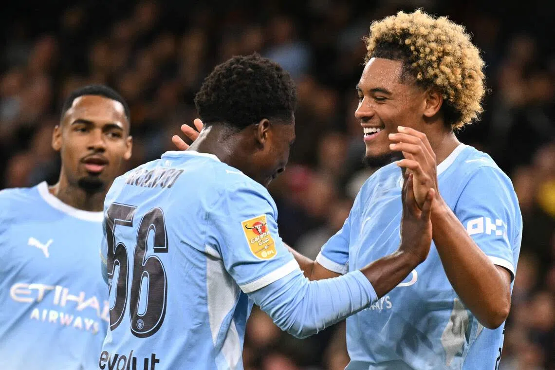 Manchester City’s French midfielder Floyd Samba (right) celebrates scoring the team’s fourth goal against Norwich City on Sept 17, with teammate Ryan McAidoo.