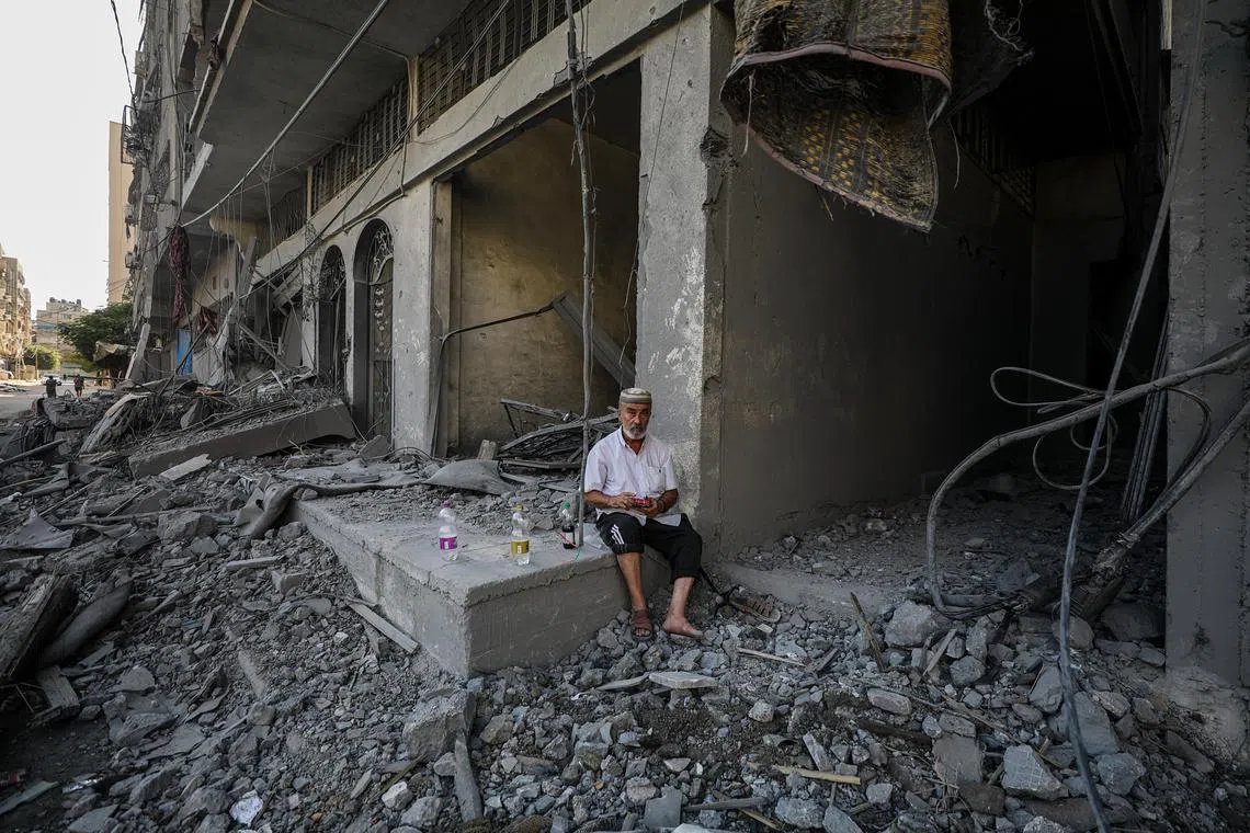 A Palestinian man sits among the rubble, following an Israeli air strike in the north of Gaza City.