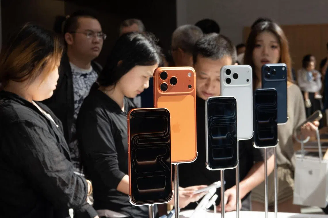 People check the new iPhone 17 lineup at an Apple store in Shanghai on September 19, 2025.