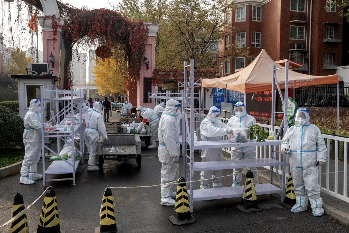 Workers in protective gear at a neighborhood placed under lockdown due to Covid-19 in Beijing, China, on Thursday, Nov. 10, 2022. Chinese stocks dropped as the nation increased Covid restrictions to curb an outbreak in a key manufacturing hub, dampening hopes of a reopening that have triggered a rally this month.