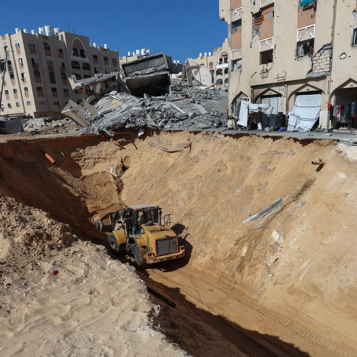 Heavy machinery operates at a site where searches for deceased hostages kidnapped by Hamas during the October 7, 2023, attack on Israel are underway amid a ceasefire between Israel and Hamas, in Khan Younis, southern Gaza Strip, October 19, 2025. REUTERS/Ramadan Abed