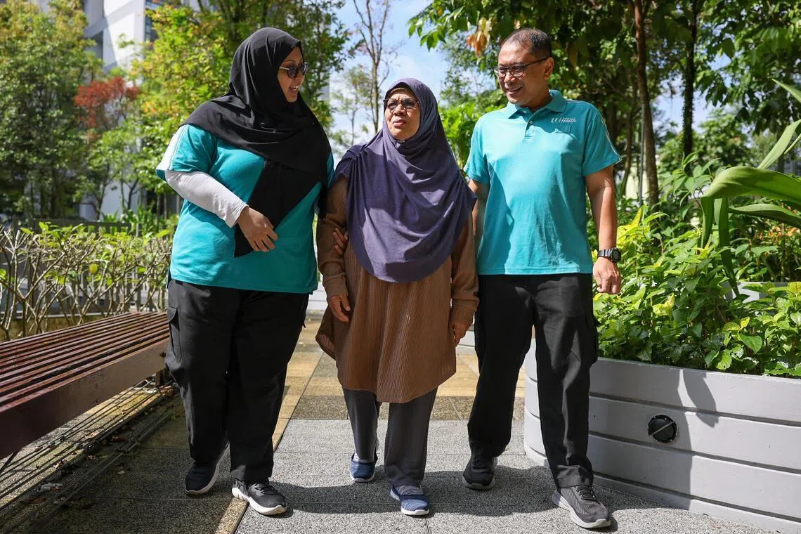 ST20260226_202671200588/Jasel Poh/sfcip01

Photo of Mdm Maria Binte Hadi, 72, (middle) walking with NTUC health staff Zainai Bin Mohamed Sharif (right) and Kamaria Binte Md Yassin at Kampung Admiralty NTUC Health Centre Rehabilitation and Wellness Centre on Feb 26, 2026.