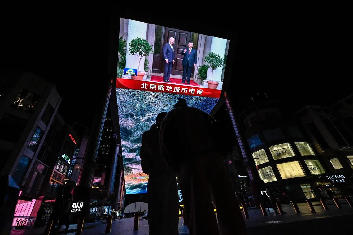An outdoor screen in Beijing shows a news programme about Chinese President Xi Jinping meeting US President Joe Biden during the Apec summit.