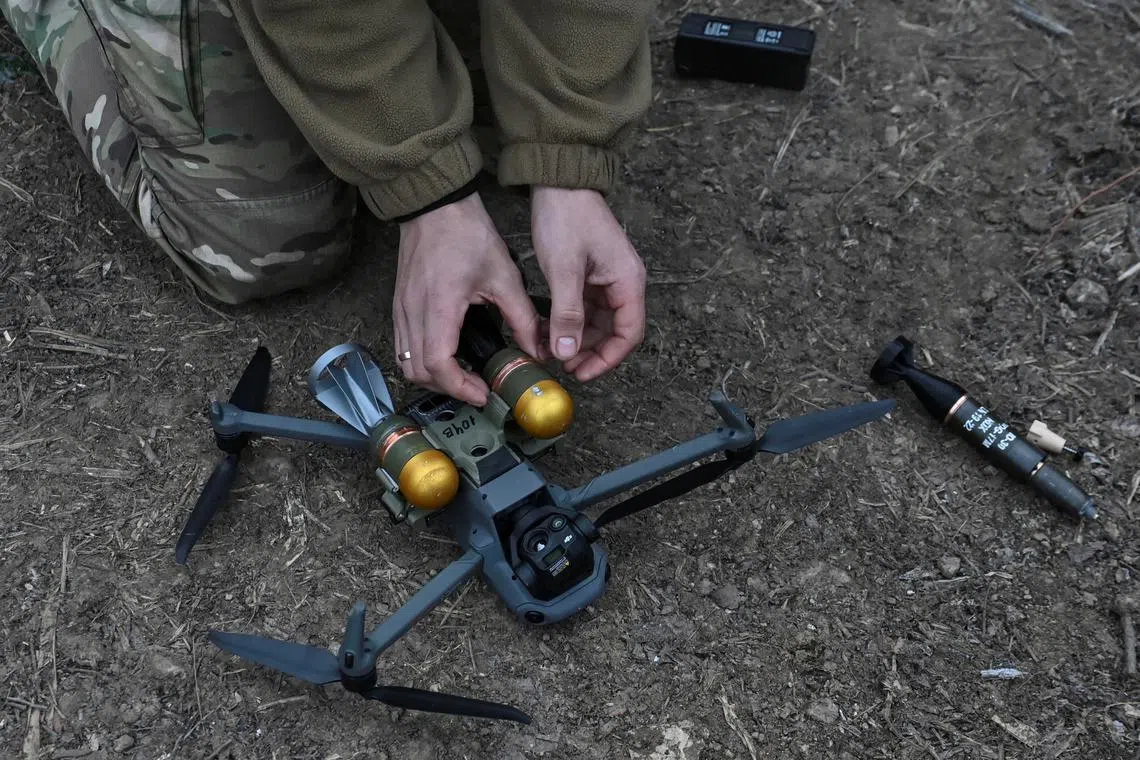 FILE PHOTO: A member of Сonsolidated Brigade 'Khyzhak' (Predator) of the Ukrainian Patrol Police Department attaches custom miniature drop bombs to a drone at a position in a front line near the town of Toretsk, amid Russia's attack on Ukraine, in Donetsk region, Ukraine December 19, 2024. REUTERS/Stringer/File Photo