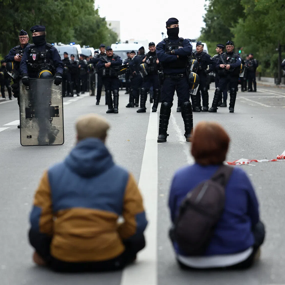 Demonstrators sit in front of officers of the French CRS riot police during a protest organised by student collectives and trade unions in Paris on Oct 22.