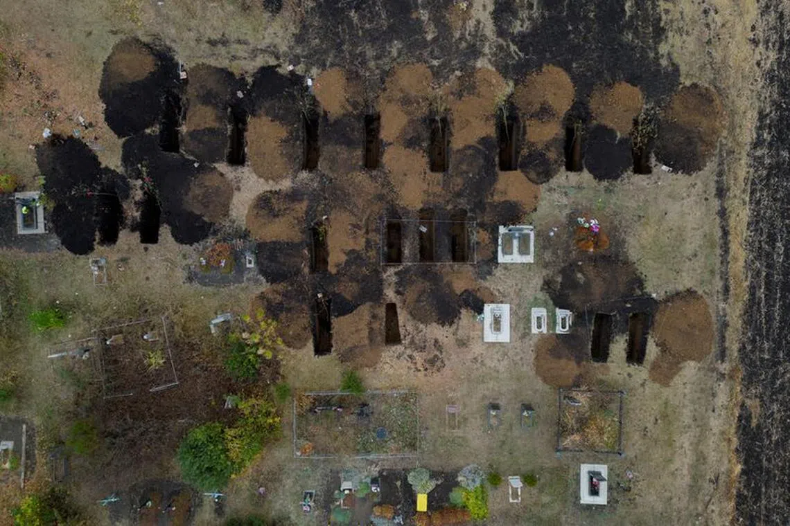 An aerial picture shows freshly dug graves at the cemetery in the village of Hroza, near Kharkiv, where at least 52 people were killed in a missile attack amid Russia's ongoing attack on Ukraine, October 8, 2023.  REUTERS/Thomas Peter/File Photo
