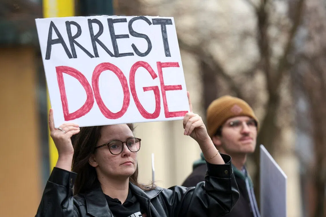 People participate in a protest against Mr Elon Musk outside of a Tesla showroom in Seattle on Feb 15.