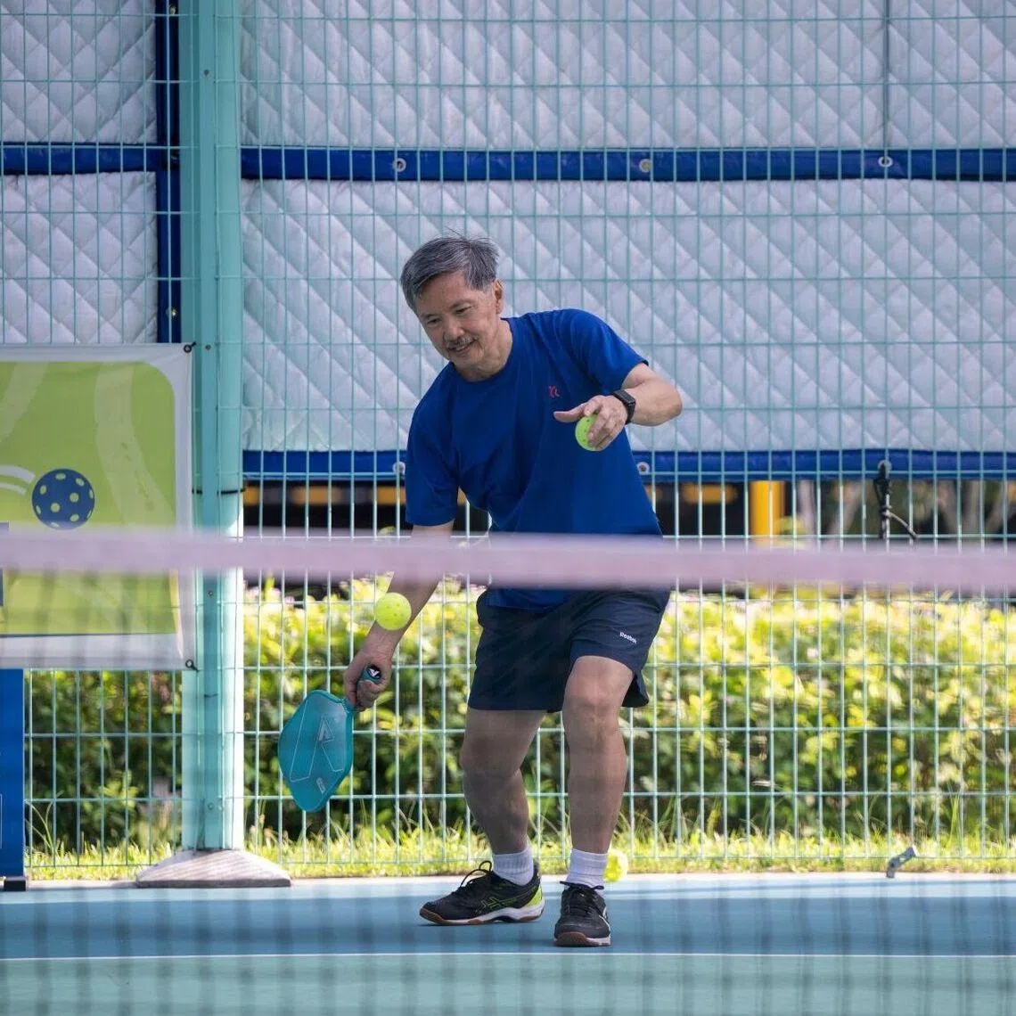 Alvin Chan, 66, participating in a friendly pickleball rally as OCBC volunteer Jonathan Chua supports from the sidelines. The training sessions are structured to help seniors progressively learn the fundamentals and rules of the sport.
