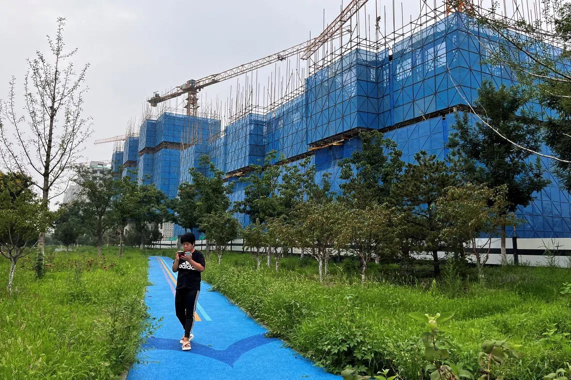 FILE PHOTO: A person walks past a construction site of residential buildings by Chinese developer Country Garden, in Beijing, China August 11, 2023. REUTERS/Tingshu Wang/File Photo/File Photo
