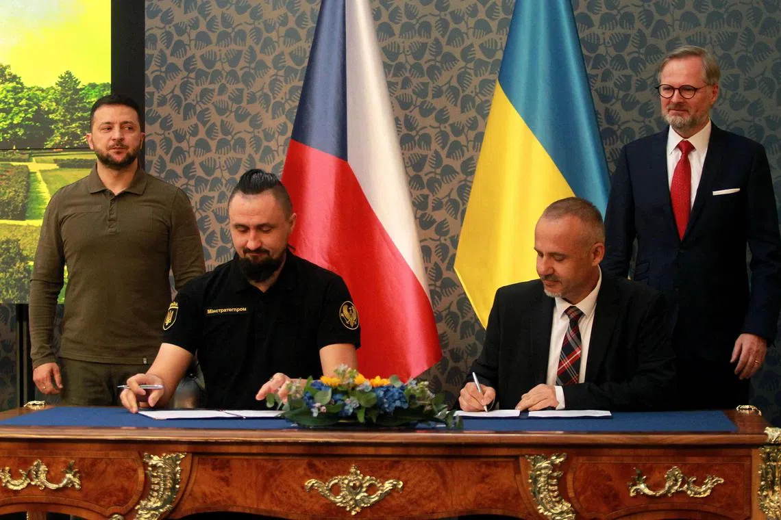 Ukrainian arms chief Oleksandr Kamyshin (seated, left) and First Deputy Minister of Defence Frantisek Sulc sign a memorandum on military cooperation with President Volodymyr Zelensky (left) and Czech Prime Minister Petr Fiala (right) looking on during a meeting in Prague on July 7. 