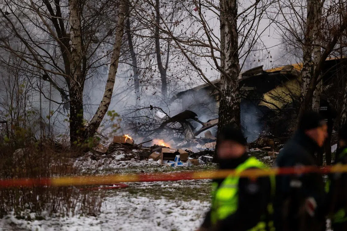 Burning packages and wreckage of the DHL cargo plane are seen at the crash site near Vilnius International Airport, Lithuania November 25, 2024. Lukas Balandis/BNS via REUTERS