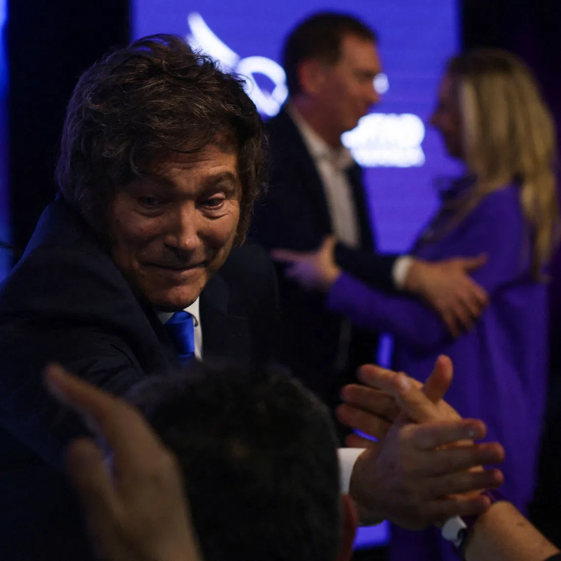 FILE PHOTO: Argentina's President Javier Milei greets people after the La Libertad Avanza party won the midterm election, which is seen as crucial for Milei's administration after U.S. President Donald Trump warned that future support for Argentina would depend on Milei's party performing well in the vote, in Buenos Aires, Argentina, October 26, 2025. REUTERS/Cristina Sille/File Photo