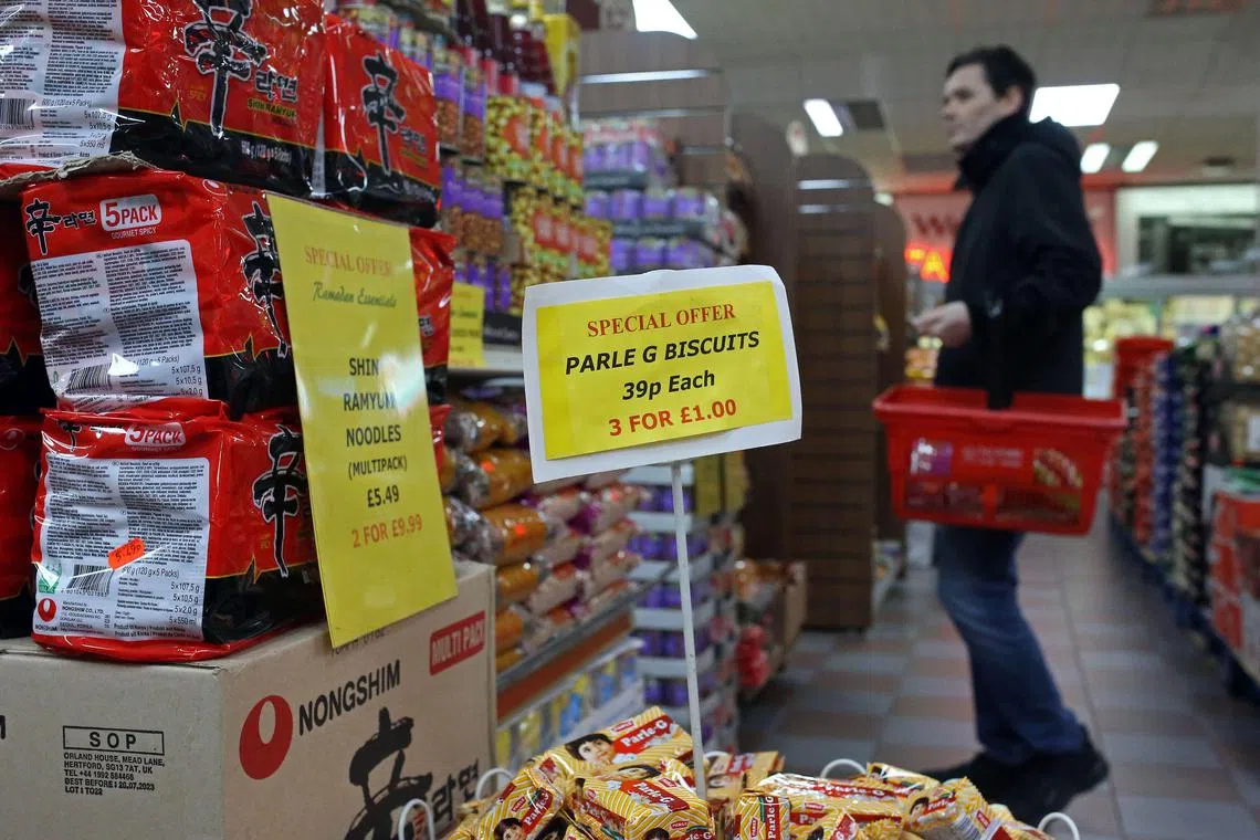 A customer shops for goods inside Taj Stores in east London on March 31, 2023. - Ramadan, which is the Islamic holy month celebrated globally and by the nearly 4 million Muslims in England and Wales, is affected by inflation in the UK hovering above 10%. Prices of food and drink in particular are rising rapidly with British stores seeing the highest grocery inflation in 18 years as of March, according to the UK’s leading retailer trade association the British Retail Consortium. Taj Stores owner has had to increase prices as well. “This makes it a bit more difficult for people already suffering from high costs of living,” said Jamal Khalique, 51, co-owner of the family-run business which sells everything from fresh produce and halal meat to delectable sweets and snacks imported from South Asia. (Photo by Susannah Ireland / AFP)
