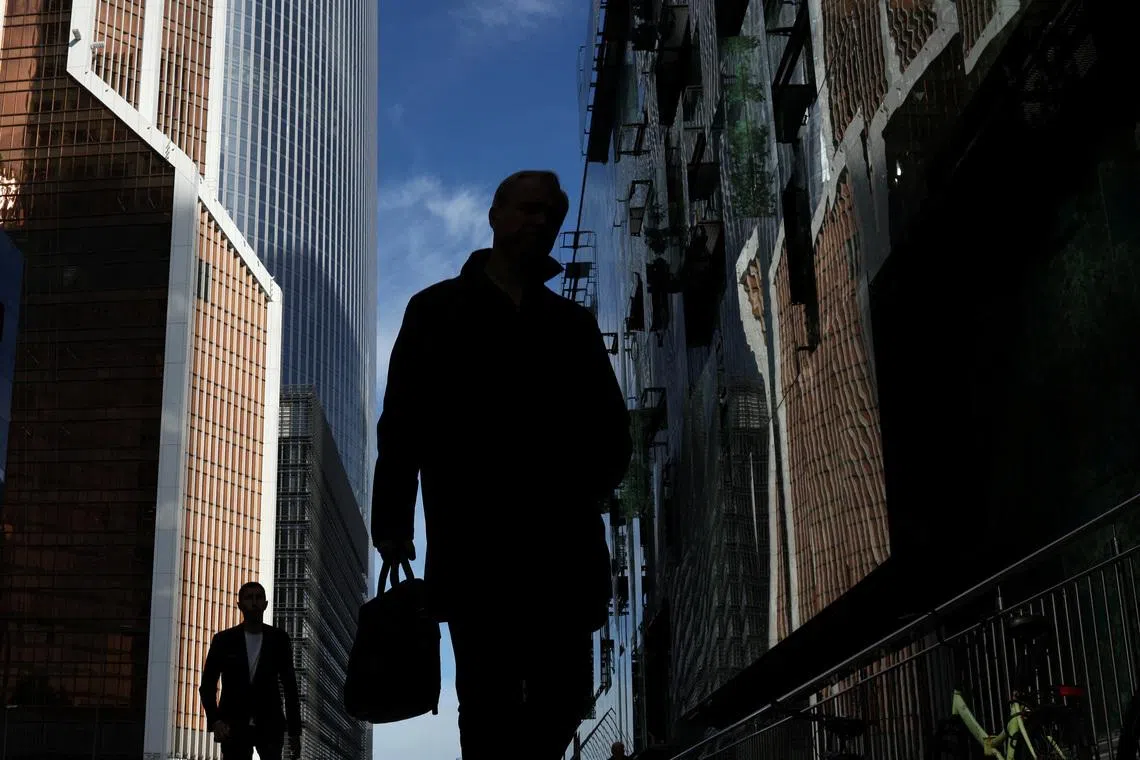 People walk at the foot of skyscrapers of the Moscow International Business Centre, also known as Moskva-City, in Moscow, Russia, October 2, 2025. REUTERS/Ramil Sitdikov