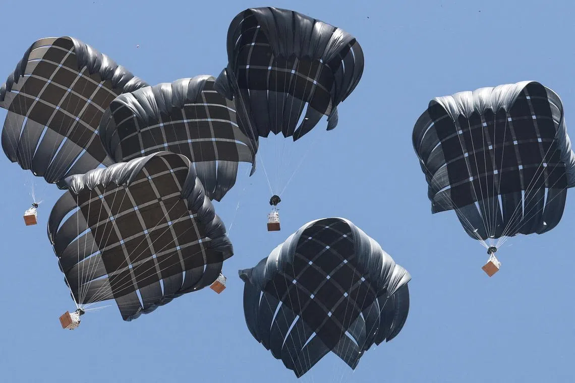 Aid packages being dropped from an airplane over Gaza, in Deir Al-Balah, in the central Gaza Strip on Aug 19, 2025. 