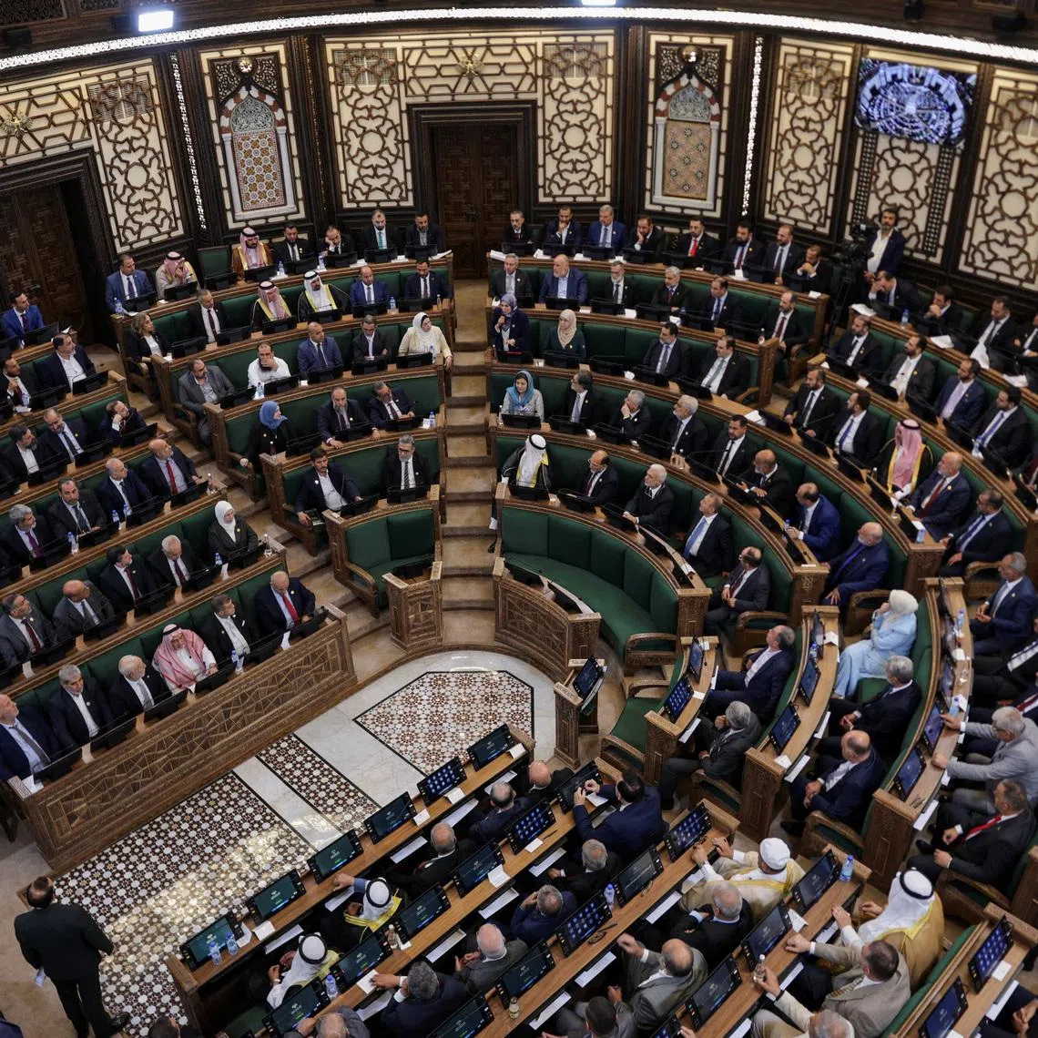 Members of Syria’s newly formed People’s Assembly on July 12 attend the first Parliament session since the end of the rule of ousted Syrian President Bashar al-Assad.