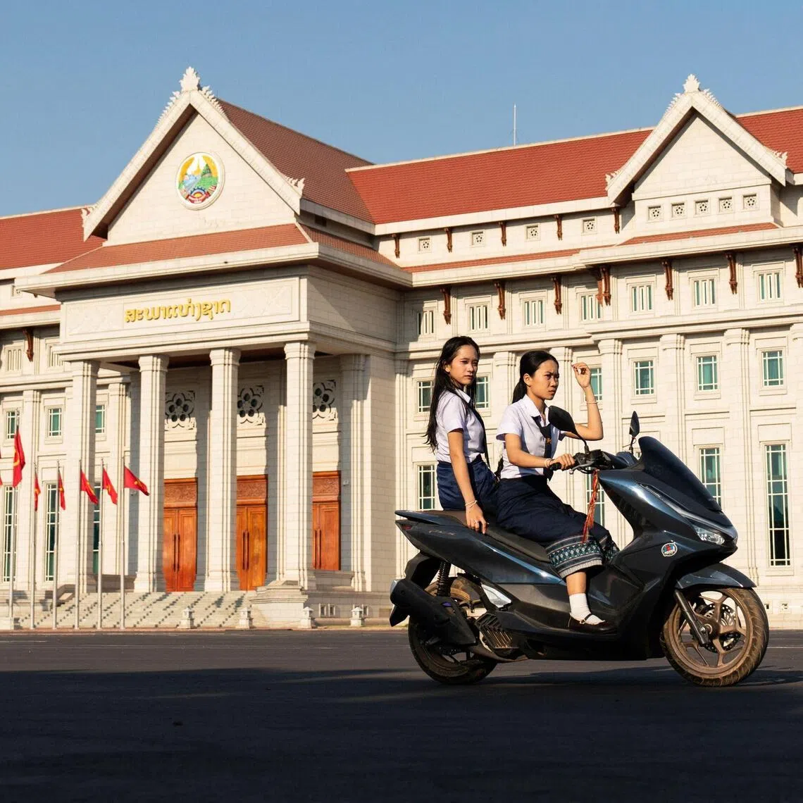 Motorists drive past the Lao National Assembly ahead of the election in Vientiane on Feb 19, 2026. The Feb 22 election would see 243 candidates contesting 175 seats after being pre-selected by the ruling communist party. 