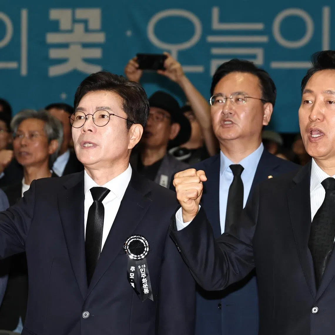 Incumbent Seoul Mayor Oh Se‑hoon (right) of the main opposition People Power Party and Chong Won‑o of the ruling Democratic Party, both candidates in the 3 June local elections, sing 'March for the Beloved,' a protest song symbolizing the 1980 pro‑democracy uprising.